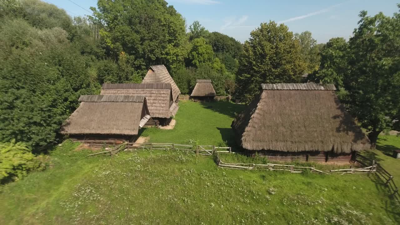 viejas cabañas de madera en un pintoresco museo al aire libre, rodeadas de árboles en verano