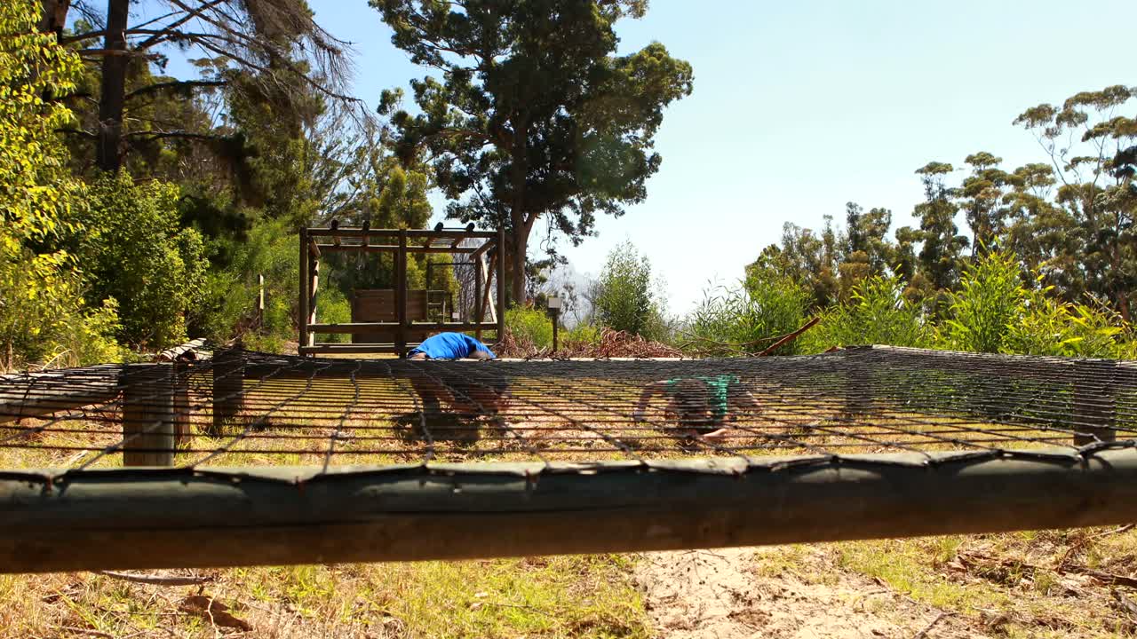 niños arrastrándose debajo de la red durante una carrera de obstáculos