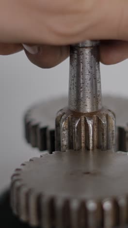 close-up of a hand operating metal gears