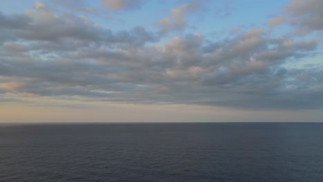 Rotating-drone-shot-of-the-Mediterranean-sea-during-golden-hour-capturing-a-sunset-and-mountains-at-Sa-Calobra,-Mallorca,-Spain