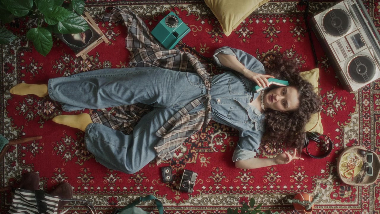 High Angle of Woman in Denim Jumpsuit Talking on Retro Rotary Phone on Carpet