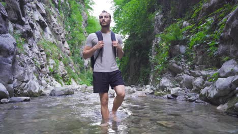 Joven-Aventurero-Caminando-Descalzo-En-Un-Arroyo-Rocoso.