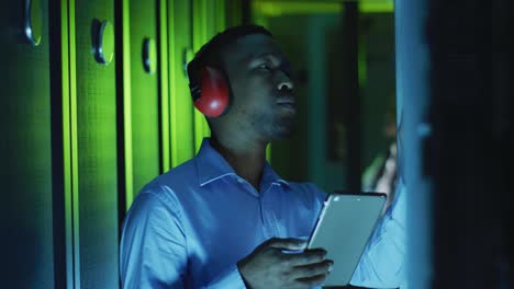 african american male computer technician using tablet working in business server room