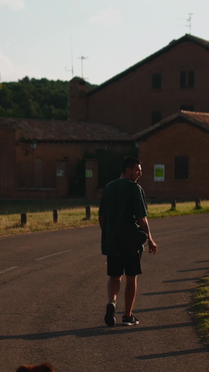 A man and his dog walking down a road