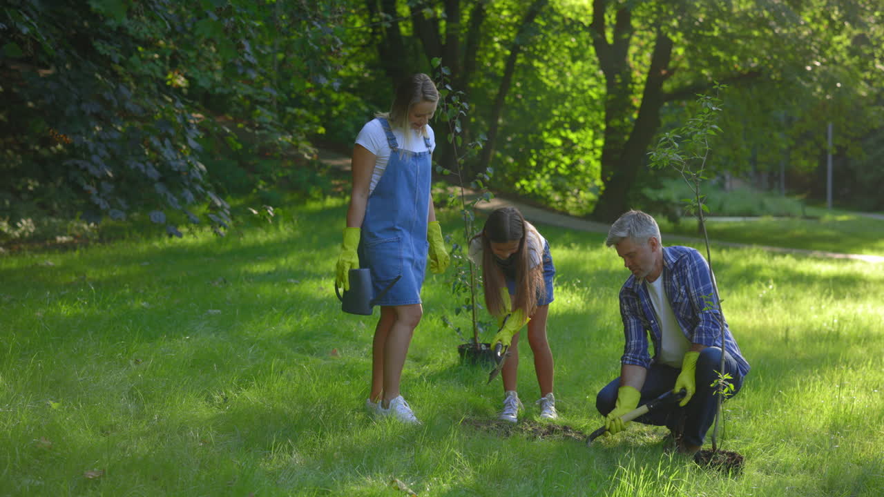 Family Planting Trees in a Park