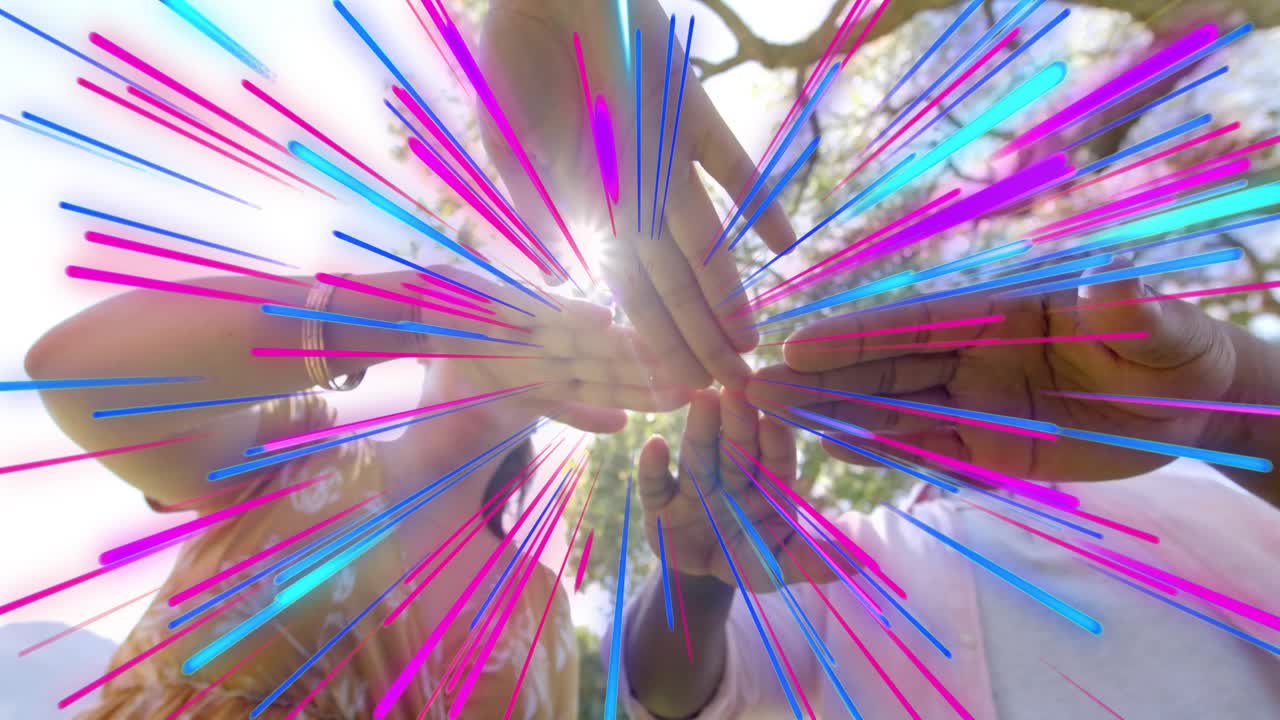 Team pressing stacked hands over low cam, causing tri-color radial streaks for business team cheer