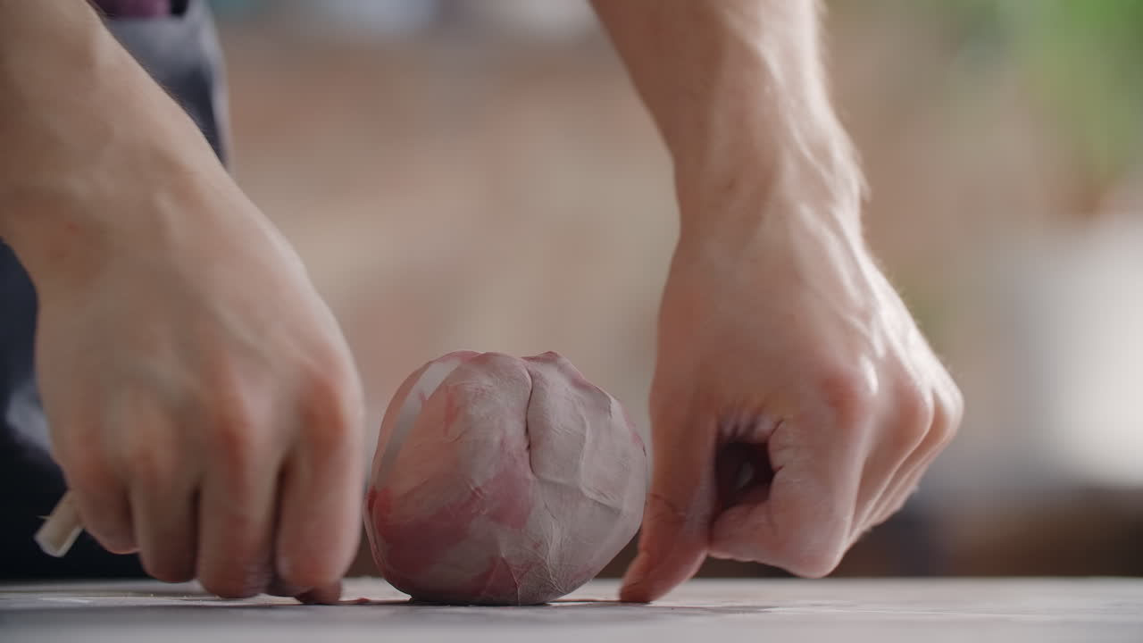Close-up view of hands shaping clay