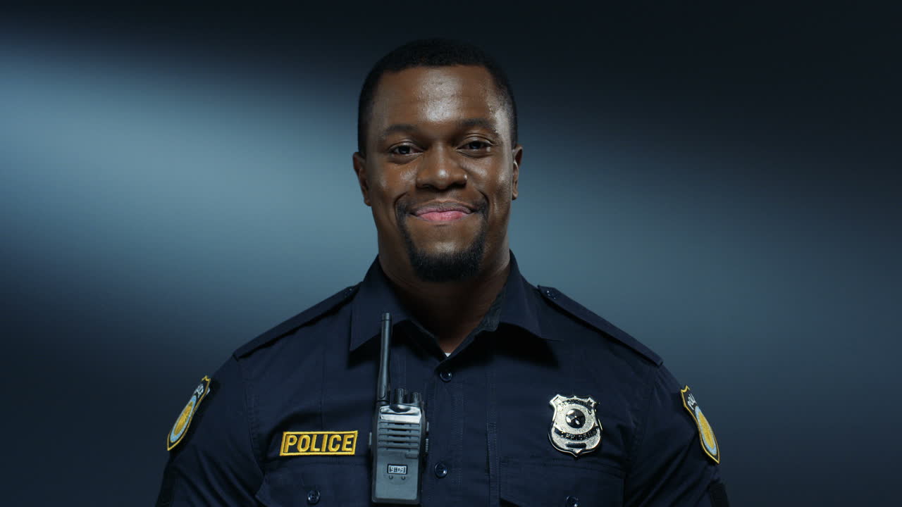 retrato del joven policía apuesto y alegre sonriendo a la cámara