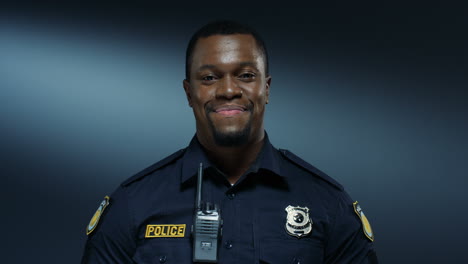 portrait of the young good looking and cheerful policeman smiling to the camera