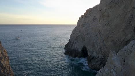 Fly-over-distinctive-El-Arco,-arch-cliffs-and-rocks,-Cabo-San-Lucas,-Mexico