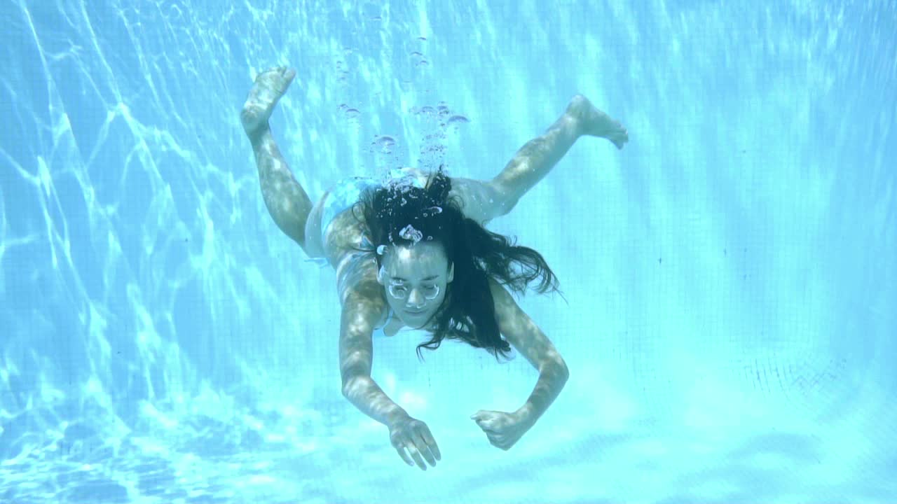 수영장에서 물속에서 수영하는 소녀