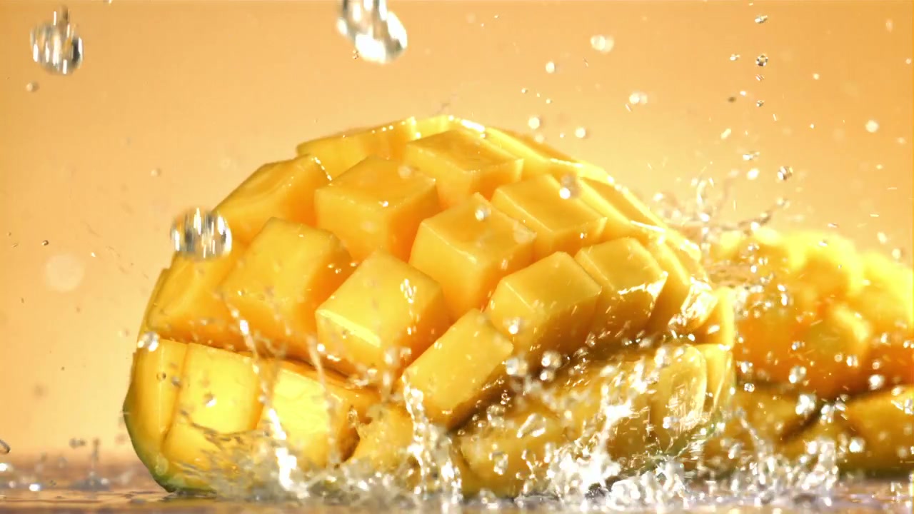 Cubetti di mango fresco che schizzano con l'acqua al rallentatore