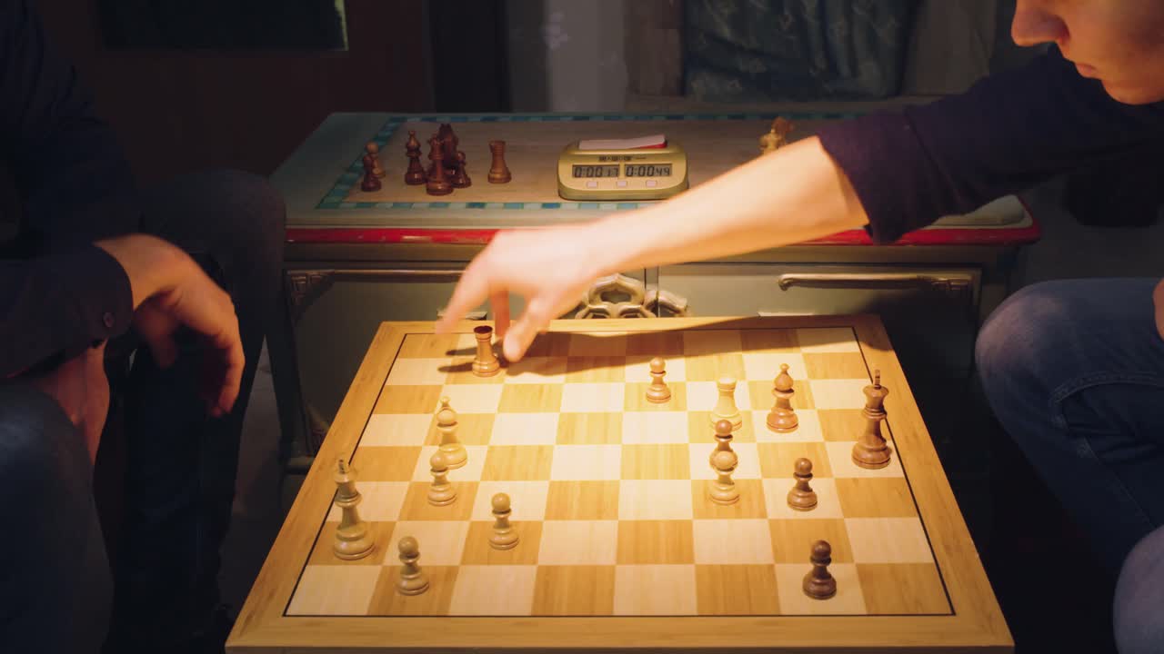 las manos de dos jugadores de ajedrez mueven las piezas alternativamente, sacando algunas piezas del tablero de ajedrez