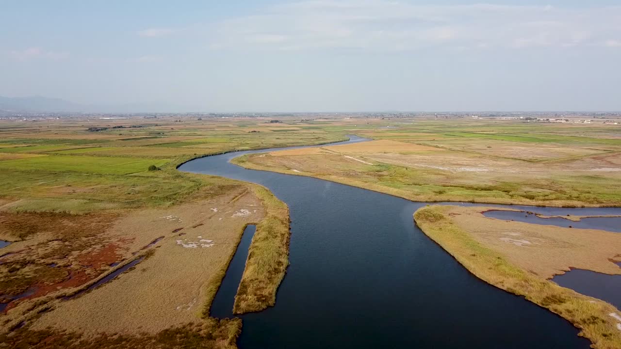 Ripresa aerea di ambientazione sopra un ampio fiume che scorre attraverso i campi, irrigazione
