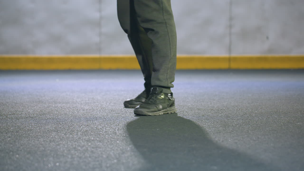 vista de la pierna de alguien hábilmente pateando una pelota de fútbol en el campo urbano bajo la iluminación del estadio por la noche, el fondo presenta un borde amarillo distinto y un entorno minimalista borroso