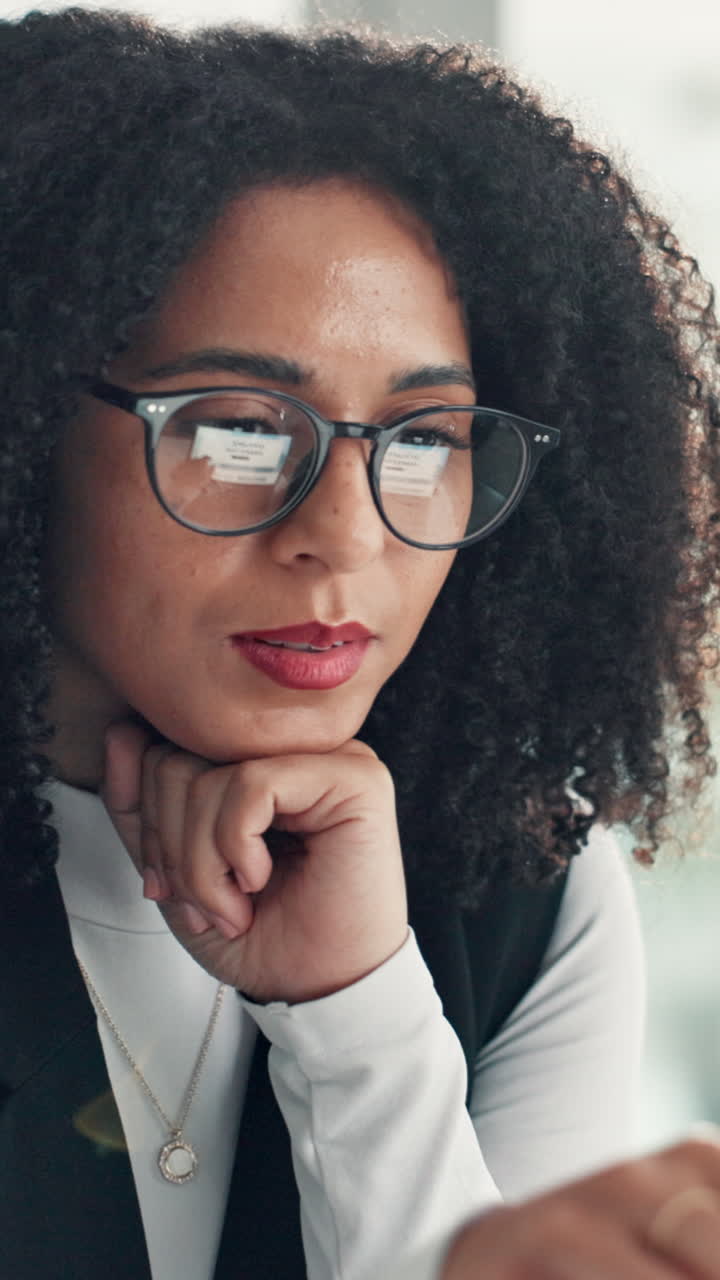Professional Woman with Curly Hair Looking at Screen and Smiling