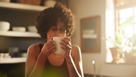 mujer disfrutando de una bebida caliente en la cocina