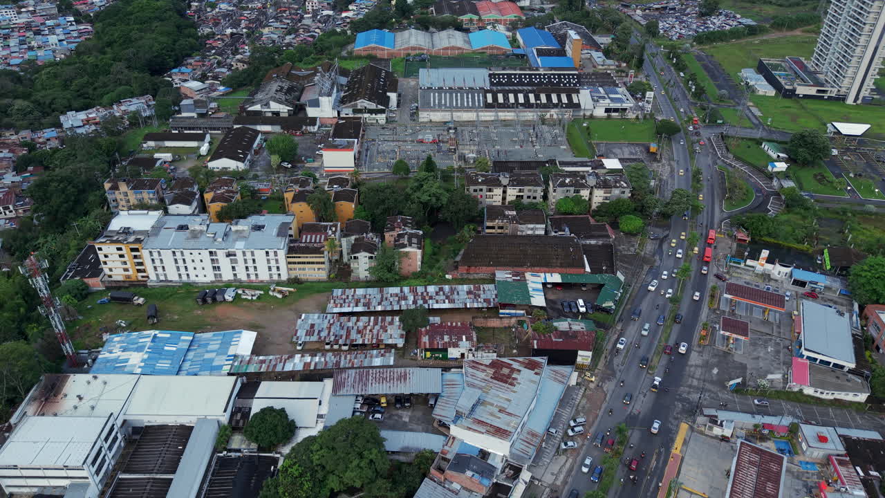 Drone shot over Ibague captures vibrant city life with bustling streets, diverse architecture, and lush surroundings under soft natural light, showcasing urban dynamics.