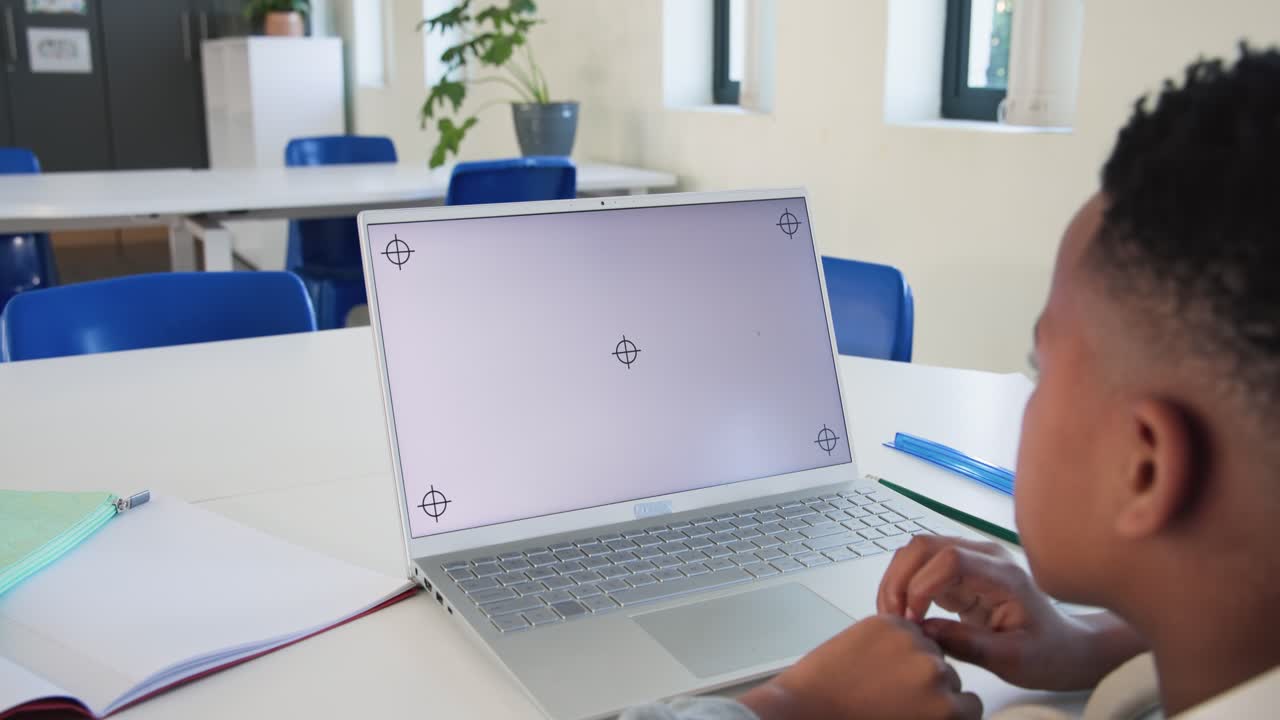 Un bambino che entra e si avvicina al tavolo tocca il touchpad del laptop e controlla i marker a mirino per la configurazione