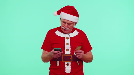 Mature-Christmas-grandfather-man-use-mobile-cell-phone,-plastic-credit-bank-card,-win-calebrate,-wow