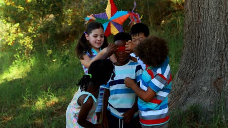 grupo de niños atando los ojos a sus amigos en el parque