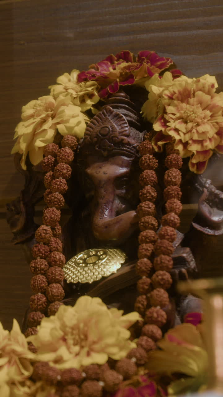 Statue of Ganesha adorned with flowers and rudraksha beads