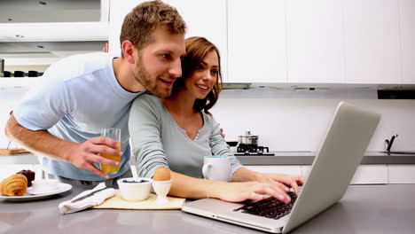 woman showing her partner something on laptop