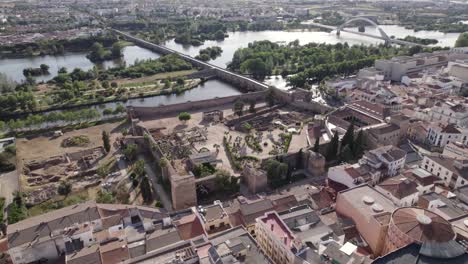 Vista-Aérea-Cinematográfica-Del-Sitio-Del-Patrimonio-De-La-Unesco,-Puente-Romano-En-Segundo-Plano