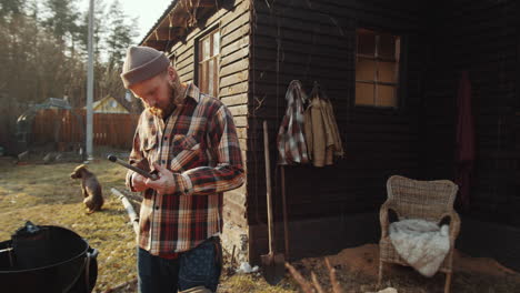 man honing knife before barbecuing outdoors