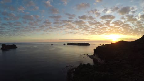 sunset over calm waters with silhouettes of islands in the distance. scenic coastal view from lan ha bay, vietnam. the vibrant sky reflects on the peaceful water creating a stunning scene
