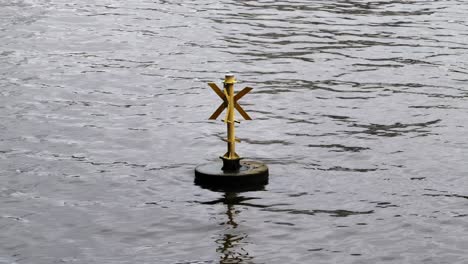 yellow buoy floating and bobbing on the thames in london.