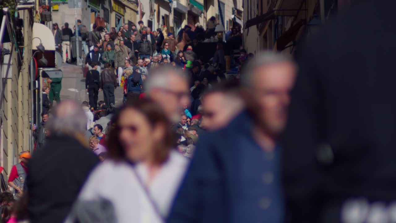 Folla vivace di persone che camminano su una strada cittadina europea.