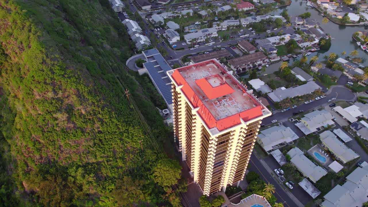 Imagens aéreas de East Honolulu, Havaí, na ilha de Oahu, com edifícios altos e residências em ambos os lados da exuberante crista vulcânica verde