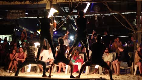 men fire twirling in front of an audience