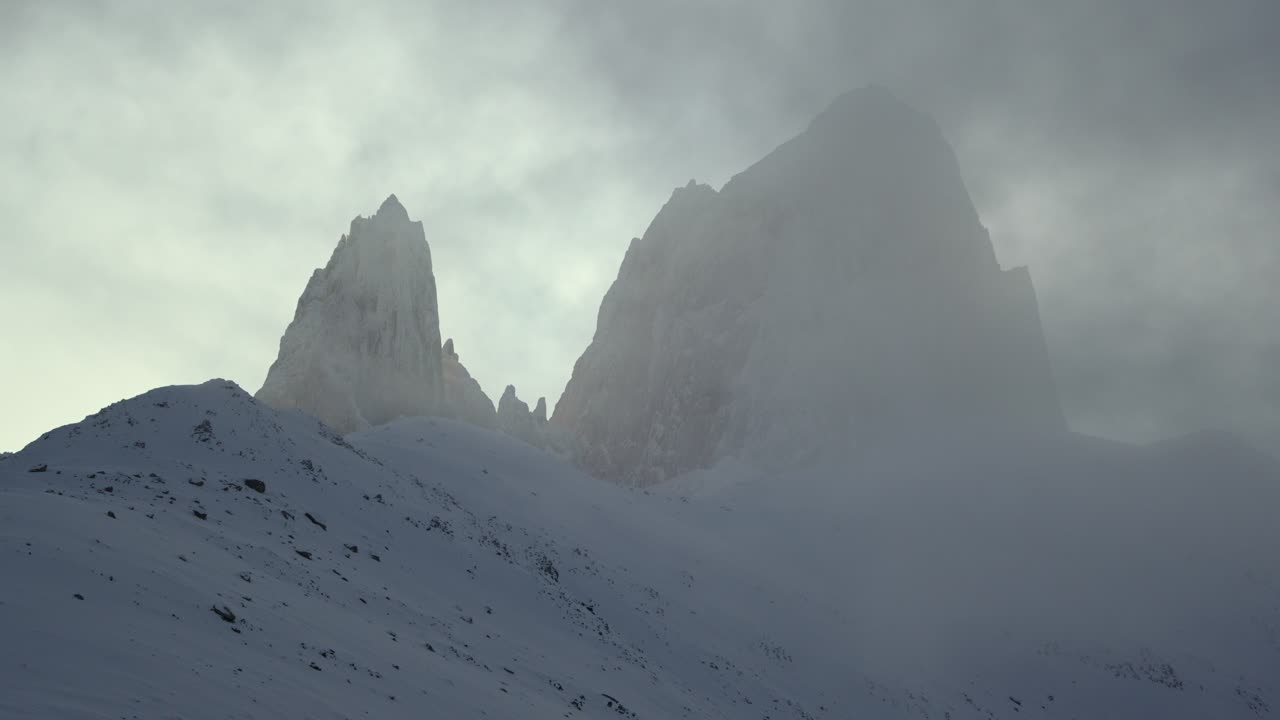 Vetta innevata del Monte Fitz Roy avvolta nella nebbia in una giornata invernale.