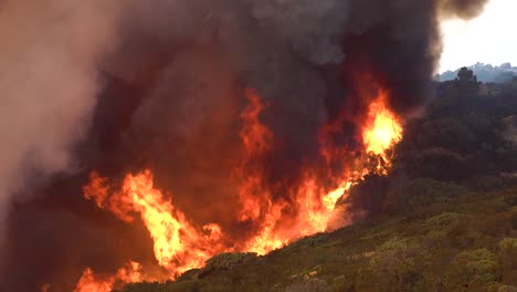 a massive fast moving wildifre burns as a huge brush fire on the hillsides of southern california during the cave fire in santa barbara