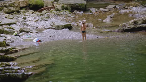 boy playing in a mountain stream