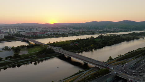 Atemberaubende-Wiener-Skyline-Bei-Sonnenuntergang-Mit-Der-Donauinsel-über-Der-Donau,-Luftaufnahme