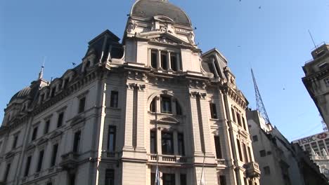 people walk around the streets in front of a large building some taking pictures