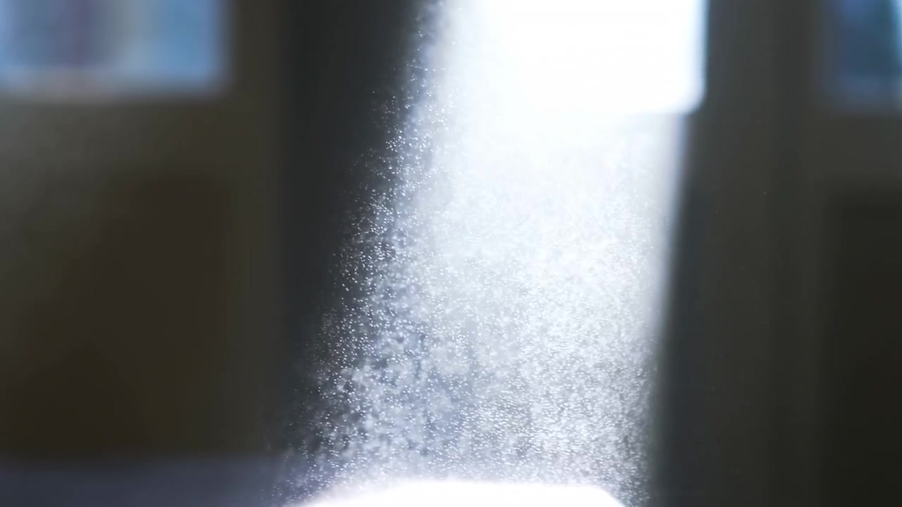 Densa nebbia verticale sale attraverso una stanza buia, con innumerevoli goccioline scintillanti che fluttuano in una fredda retroilluminazione, morbidi riflessi della finestra, un bagliore sottile e un contrasto atmosferico in tutta la scena.