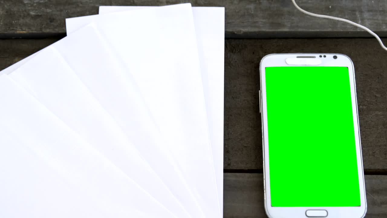 Fogli bianchi, cellulare, cuffie e tablet su tavolo 4k