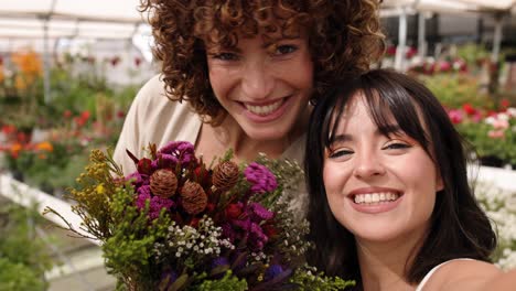 florists posing with bouquet in greenhouse