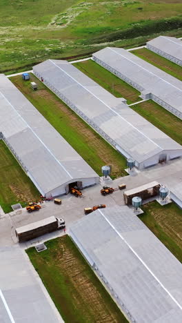 aerial view on contemporary farm complex. flight over agricultural territory with modern structure for livestock. slow motion. vertical video