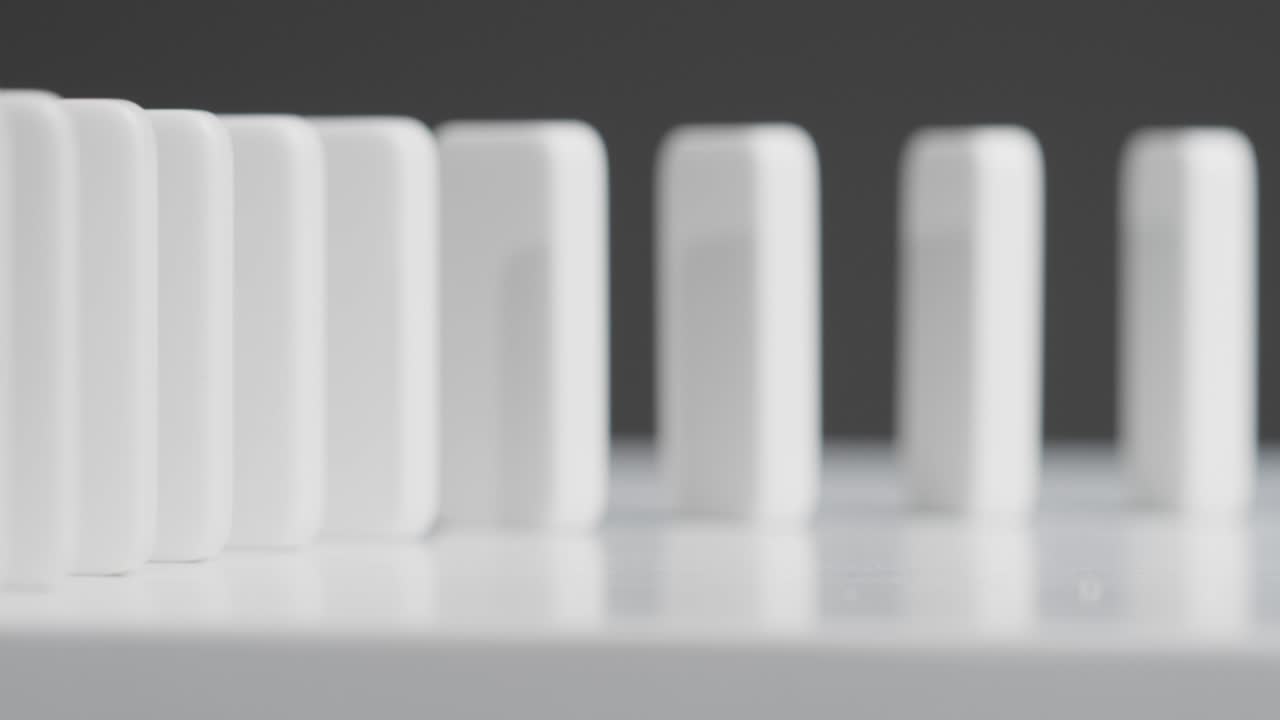 plano medio de alguien empujando fichas de dominó