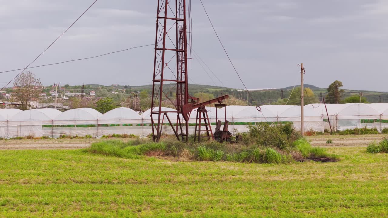 Oil field near Berat, Albania with pumpjack in a green landscape