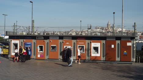 personas que usan cajeros automáticos en una estación de la ciudad de estambul