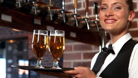 smiling barmaid serving glasses of beer