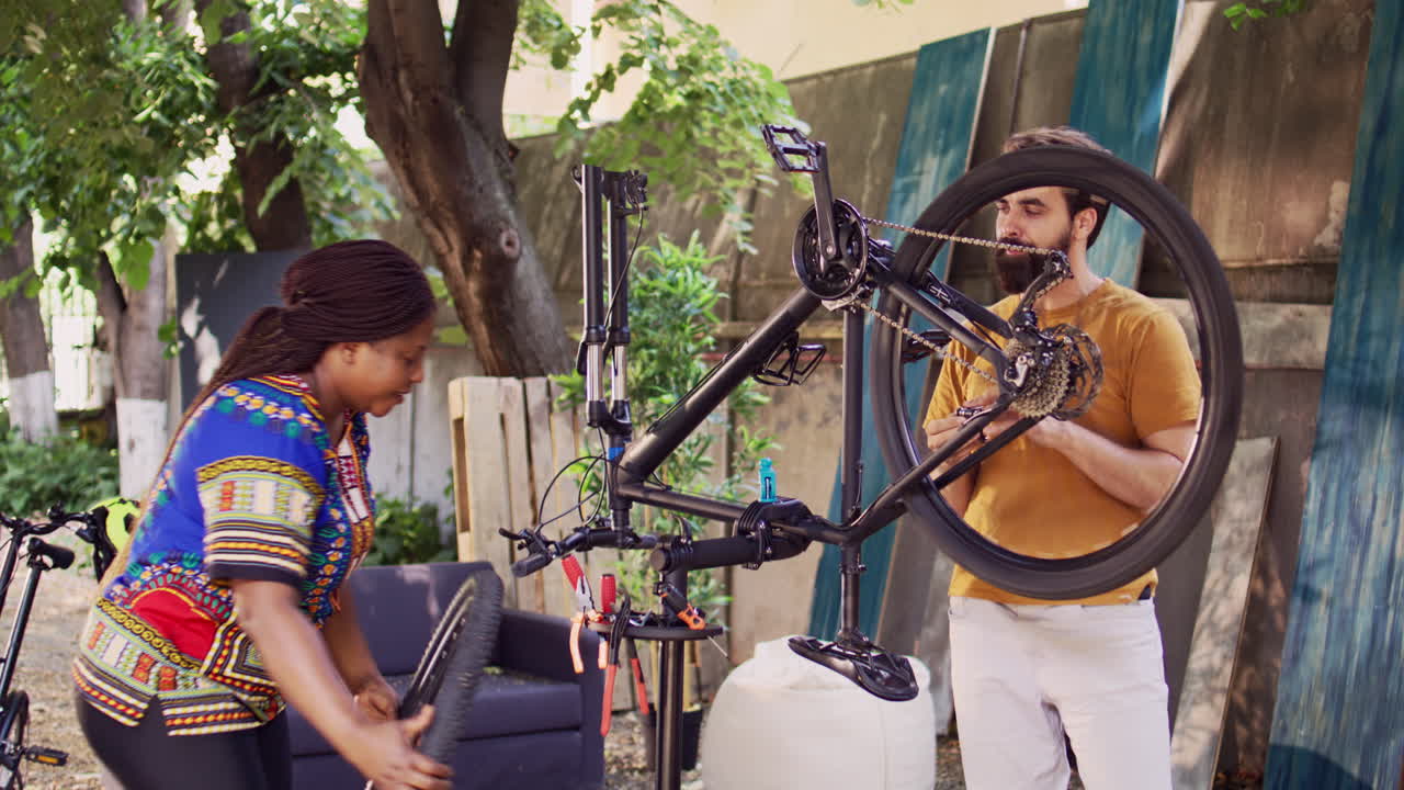 pareja reparando una bicicleta dañada en el patio
