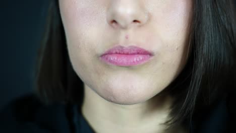 young woman chewing wet moist nicotine tobacco snus product, close up