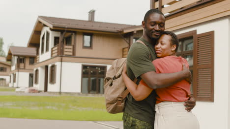 pareja amorosa abrazándose fuera de casa antes de que el hombre vaya al servicio militar